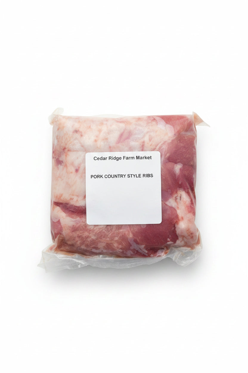 Packaged pork country style ribs with a label from Cedar Ridge Farm Market on a metal surface.