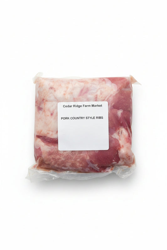 Packaged pork country style ribs with a label from Cedar Ridge Farm Market on a metal surface.