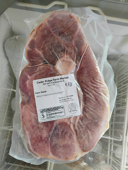 Packaged ham steak with a label on a metal surface