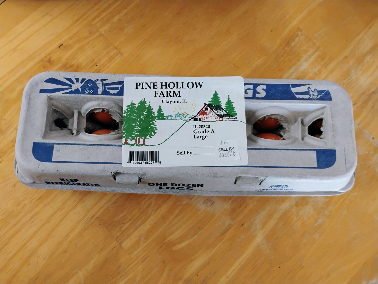 Carton of eggs with a label on a wooden surface
