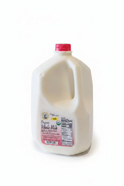 Jug of organic whole milk on a white surface with a kitchen background